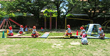 園児たちがグラウンドで遊んでいる写真